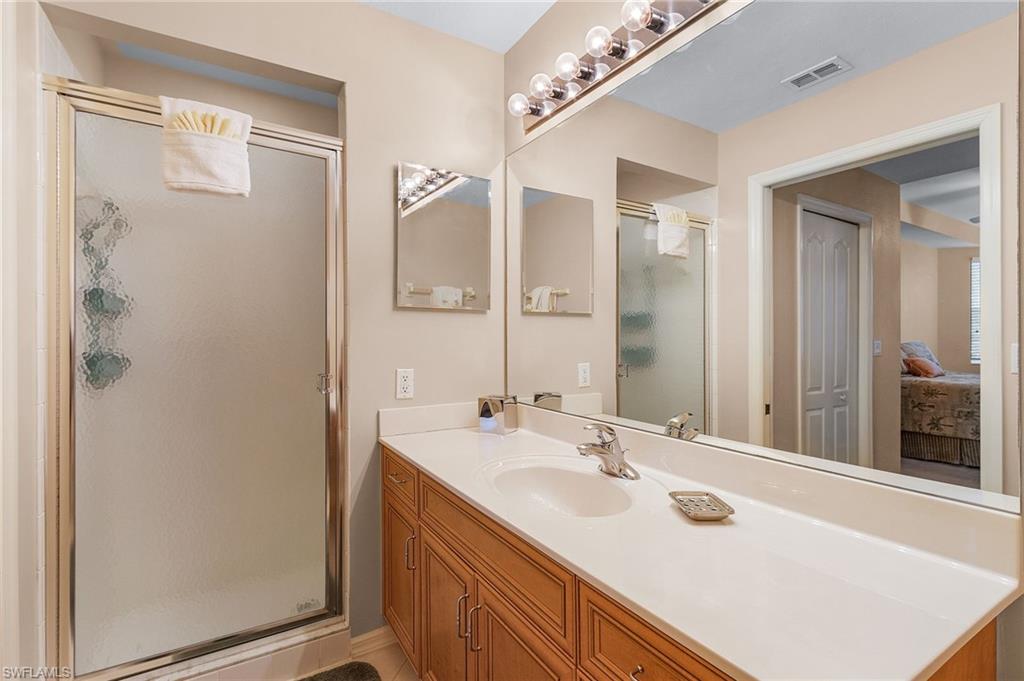Bathroom featuring a large vanity with wood-finish cabinetry, a single basin sink, and a spacious countertop