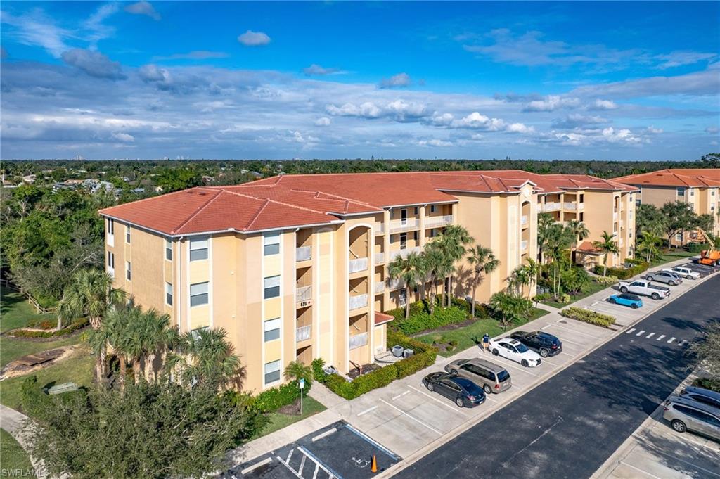 Multi-story residential building featuring a terracotta tile roof and numerous private balconies