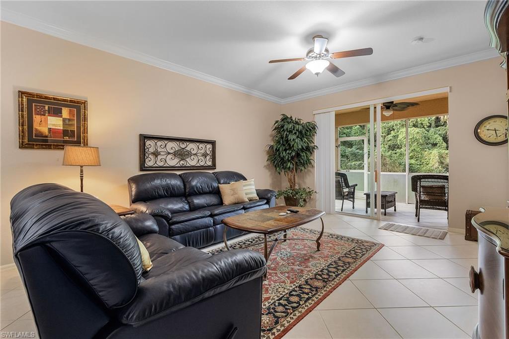 Living area featuring tile flooring, crown molding, and a ceiling fan with integrated lighting