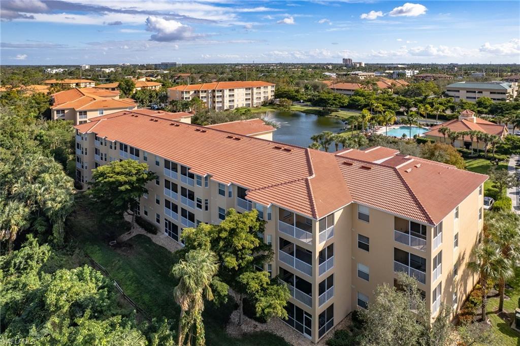 Multi-story residence featuring a tile roof, screened balconies, and light-toned exterior siding