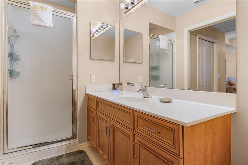 Bathroom vanity with a light-toned countertop and wood-finish cabinetry