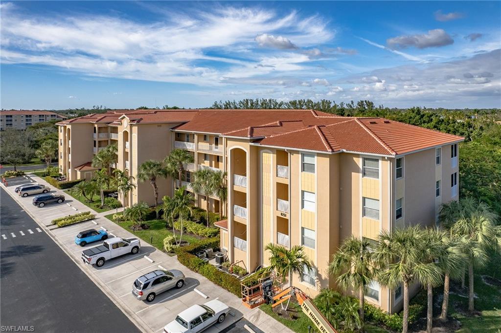 Multi-story residential building featuring a terracotta tile roof and stucco exterior