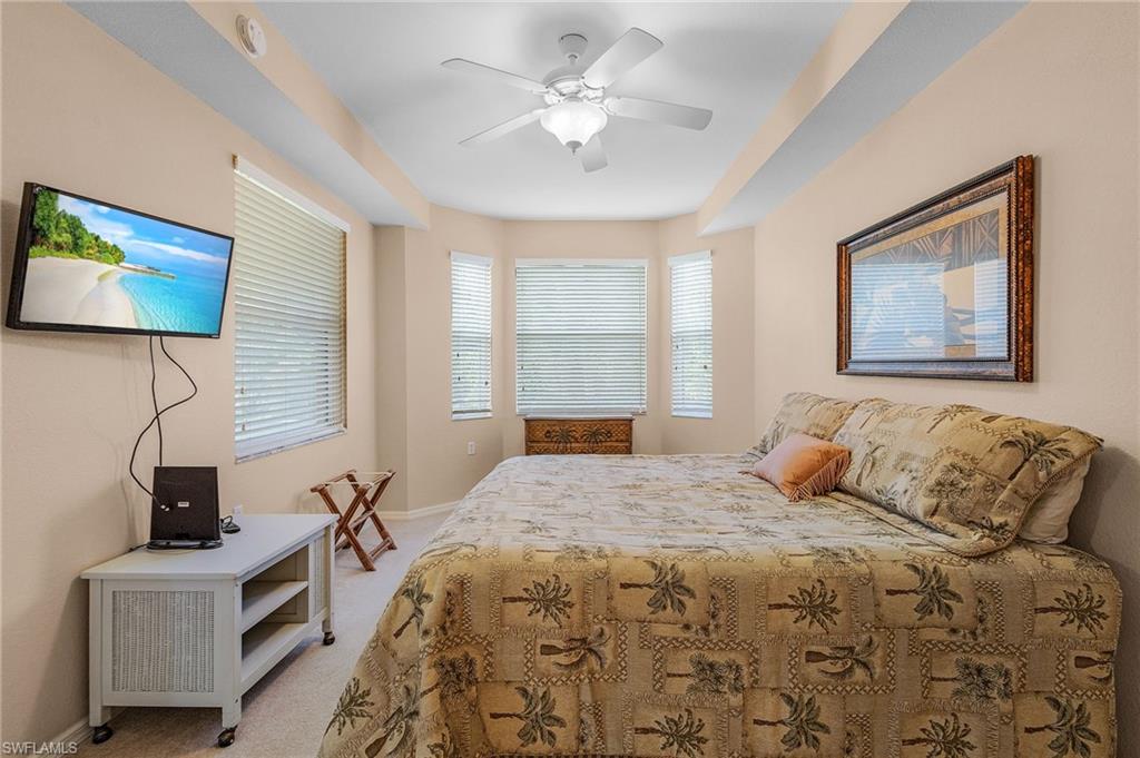 Carpeted room featuring a bay window, ceiling fan, and recessed lighting
