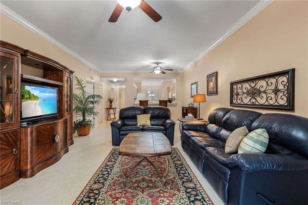 Spacious living area featuring light-toned flooring and crown molding