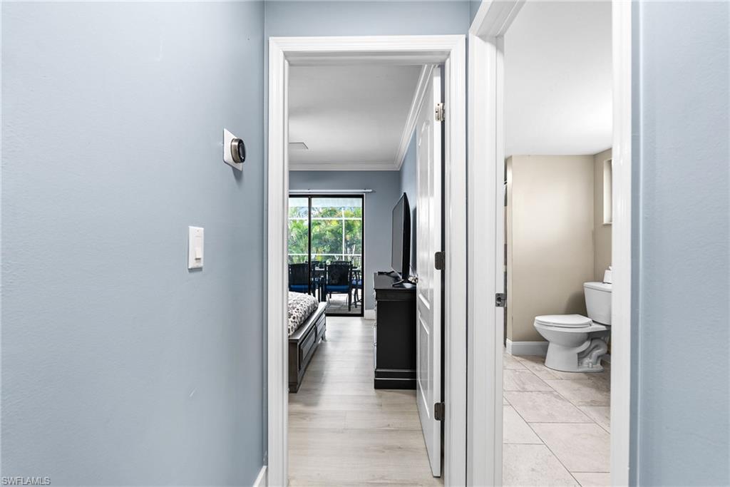 Hall with ornamental molding and light wood finished floors
