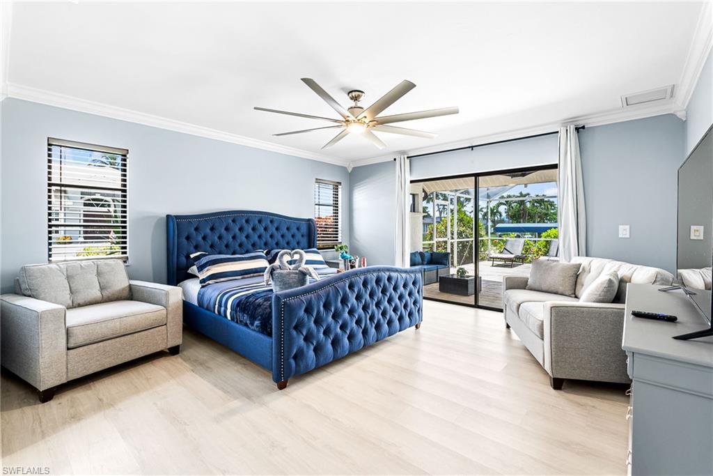 Bedroom featuring crown molding, access to exterior, light wood-type flooring, and ceiling fan