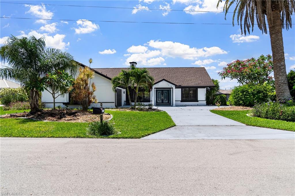 Single story home with driveway, a front lawn, and roof with shingles