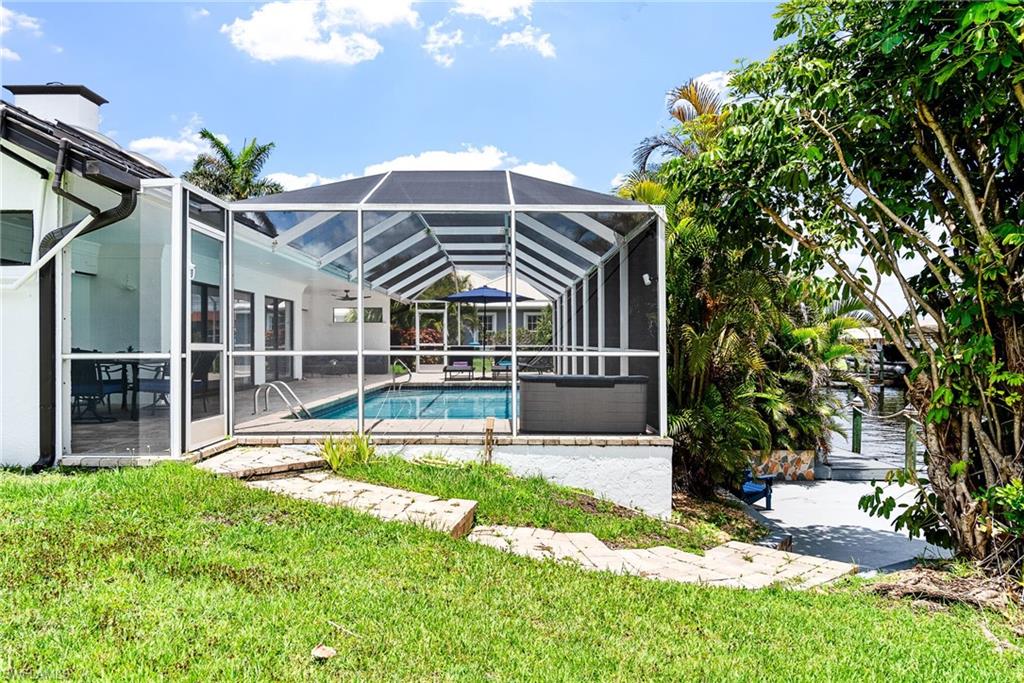 Swimming pool featuring a patio, a sunroom, a lanai, and a yard