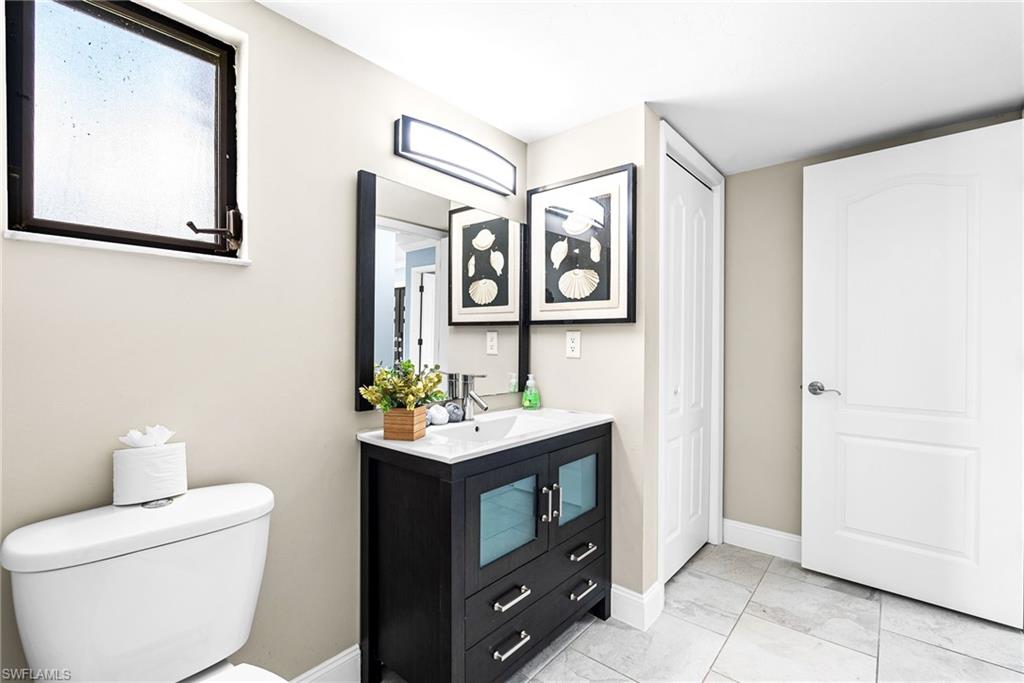 Half bath with vanity and light tile patterned flooring