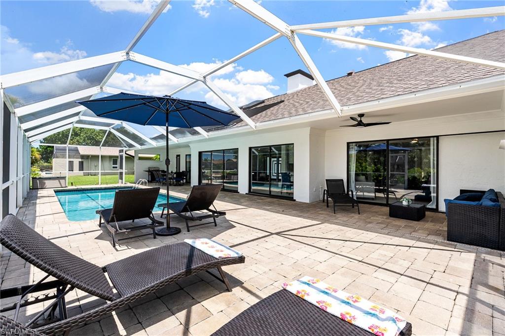 View of patio with a sunroom, a lanai, outdoor lounge area, and an outdoor pool