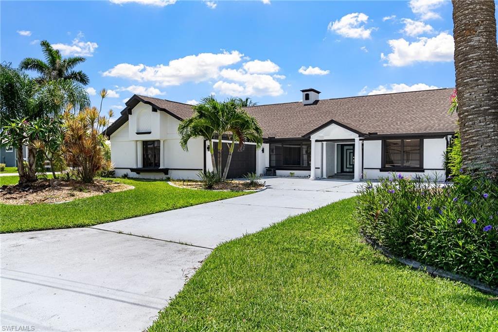 View of front of home featuring a front lawn, driveway, roof with shingles, stucco siding, and an attached garage