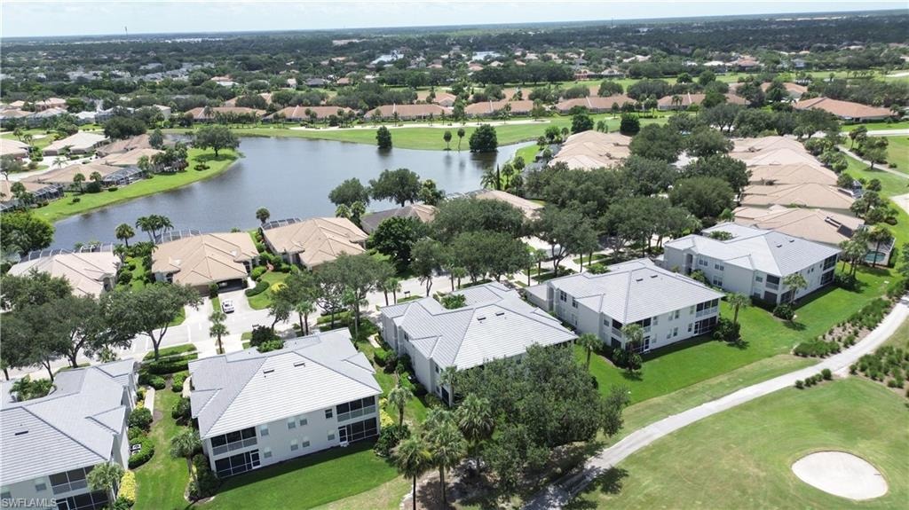 Aerial view of residential area featuring a nearby body of water and a local golf course