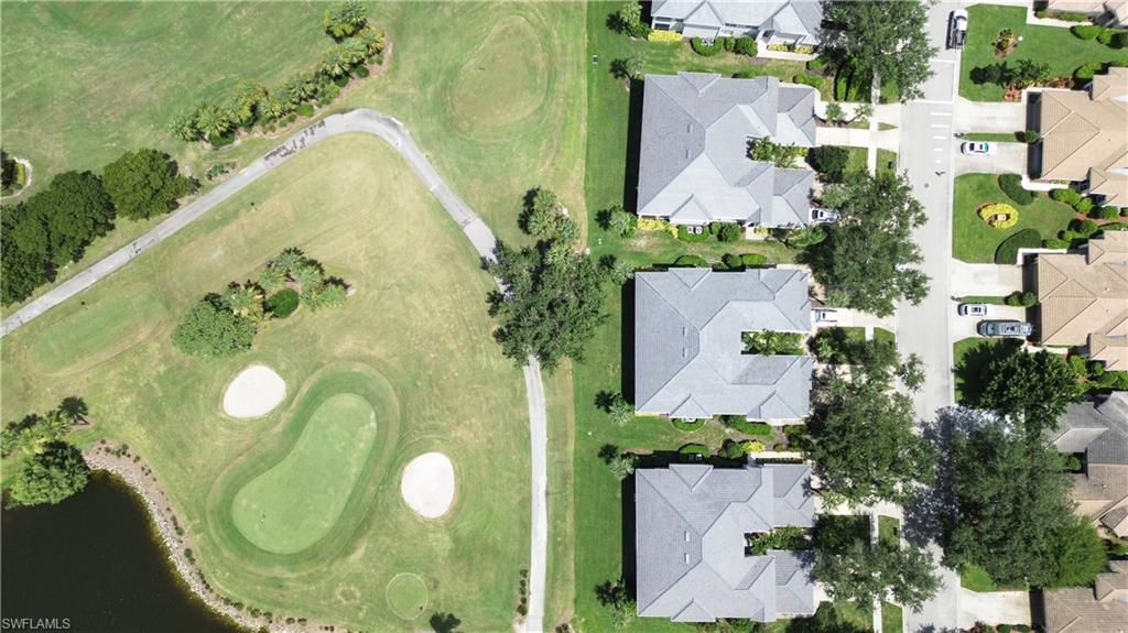 Aerial view of property and surrounding area with nearby suburban area, a golf course, and a nearby body of water