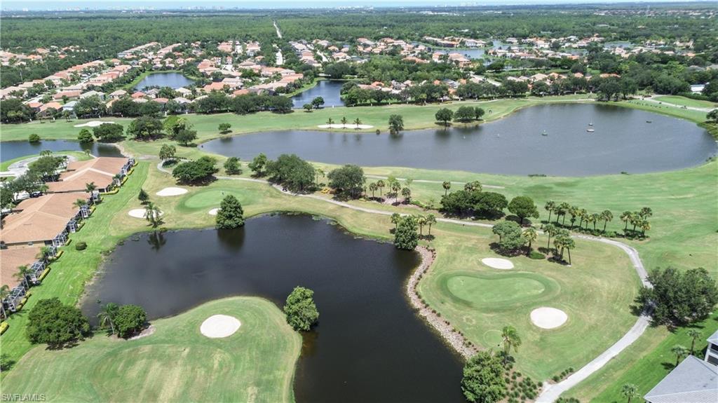 Aerial view of property and surrounding area with a golf course and nearby suburban area