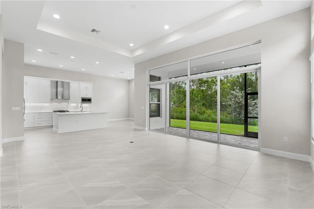 Spacious open floor plan with 12' ceilings featuring transom windows for elegance and natural light.  Oversized 24"x24" porcelain tile throughout the home.