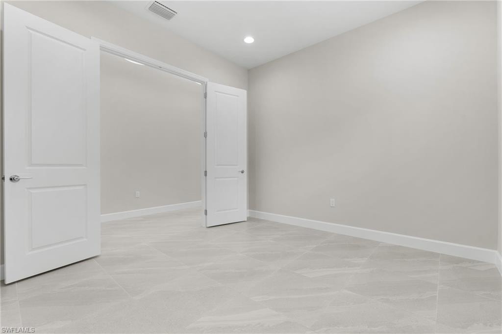 Large den area with double doors, recessed lighting.