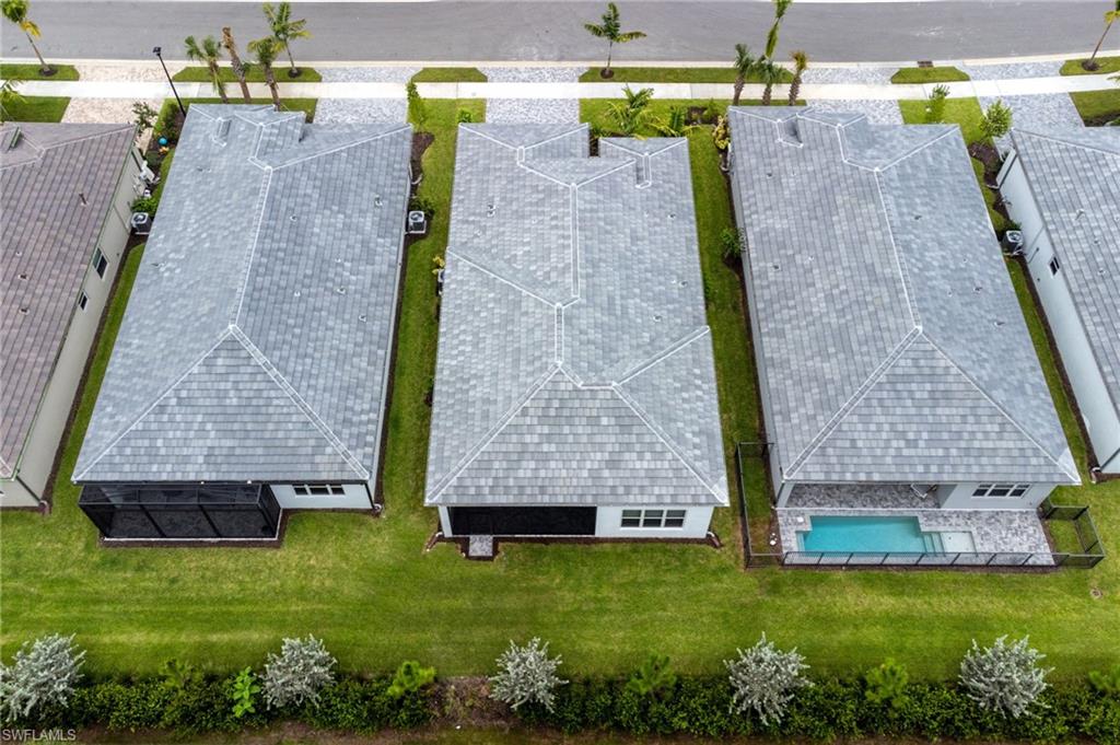 Contemporary home featuring a gray shingle roof and a screened-in private patio