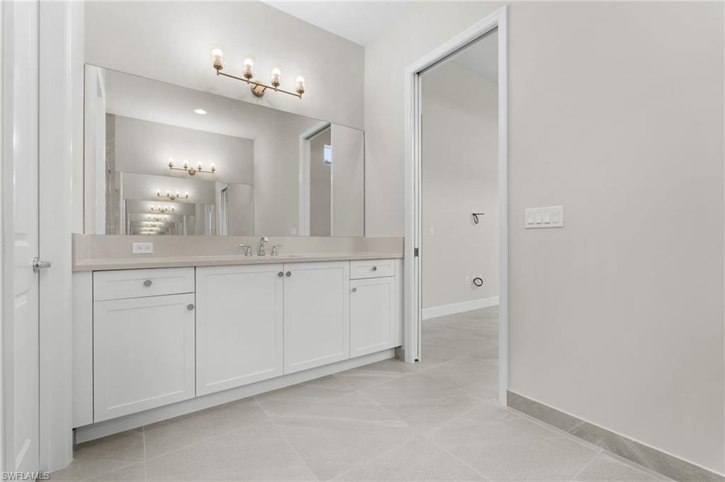 Primary bathroom 2nd vanity featuring a wide vanity with white cabinetry, a light, quartz countertop, and a large mirror.
