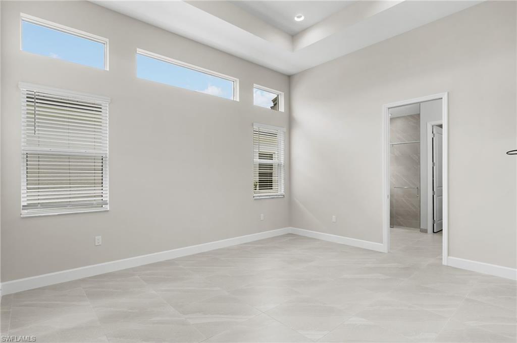 Primary suite with ensuite bathroom, 2 walk-in closets, coffered ceiling, transom windows.
