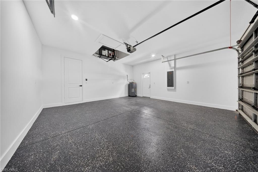 Spacious garage featuring a durable epoxy floor, white walls, and bright overhead lighting