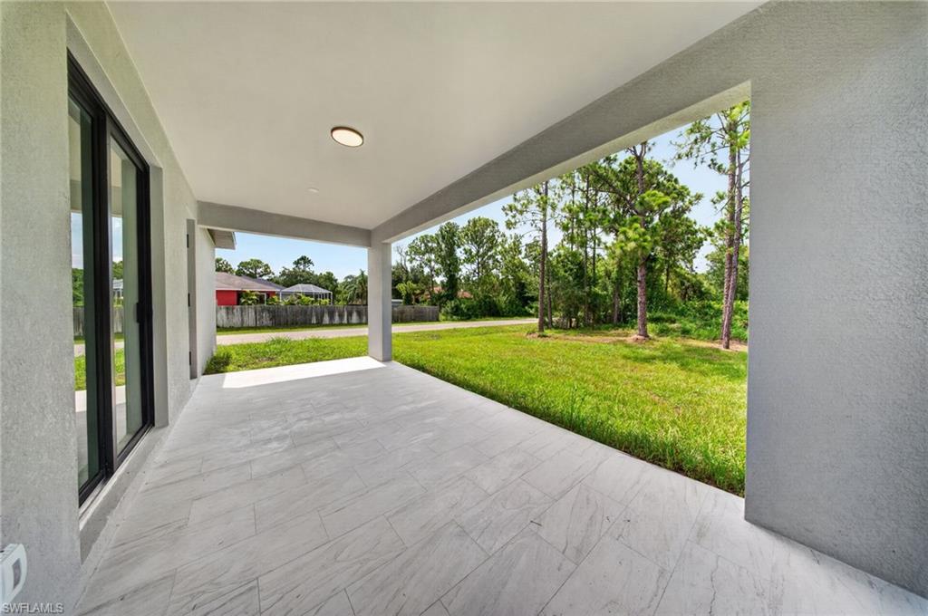 Covered outdoor patio featuring light-toned large format tile flooring, recessed ceiling lighting, and a stucco finish