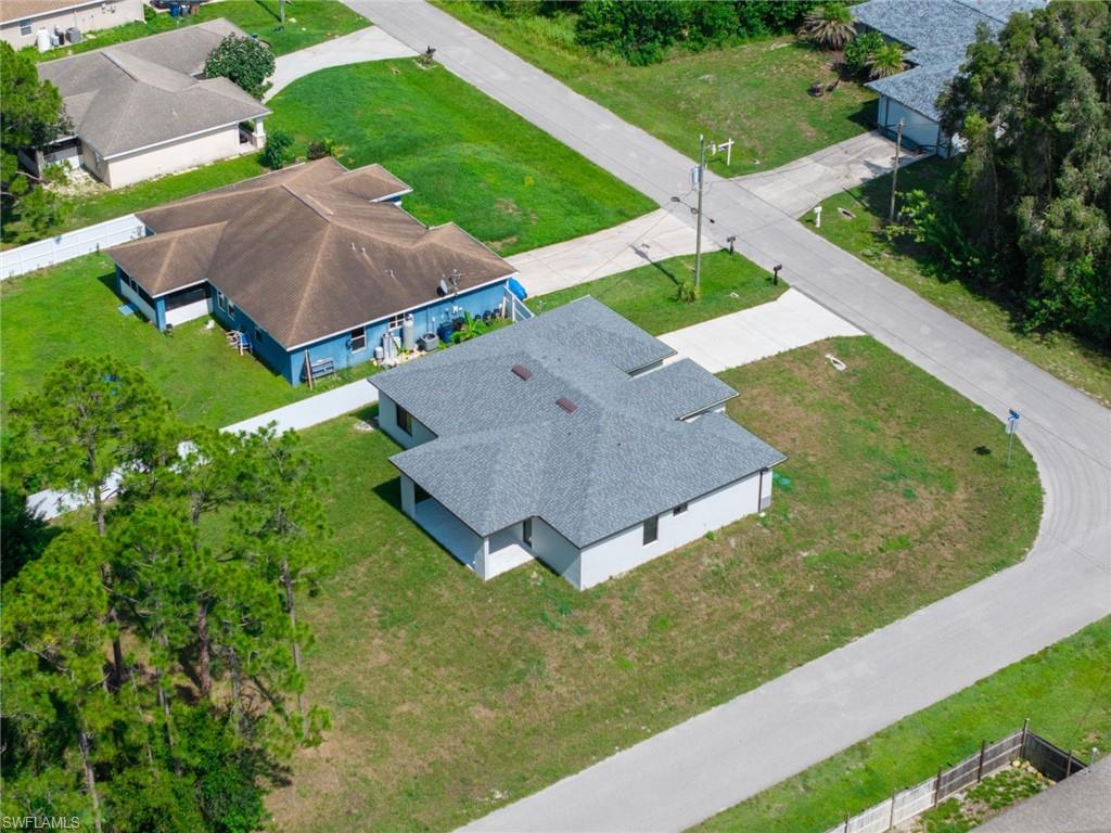 Single-story residence featuring a gray shingle roof, light-colored exterior walls, and a visible driveway leading to the street