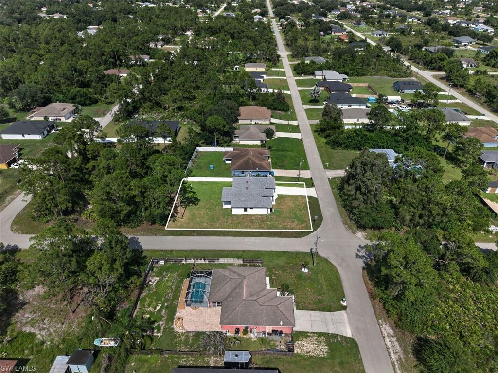 Aerial perspective highlighting a corner lot with a white-outlined property boundary