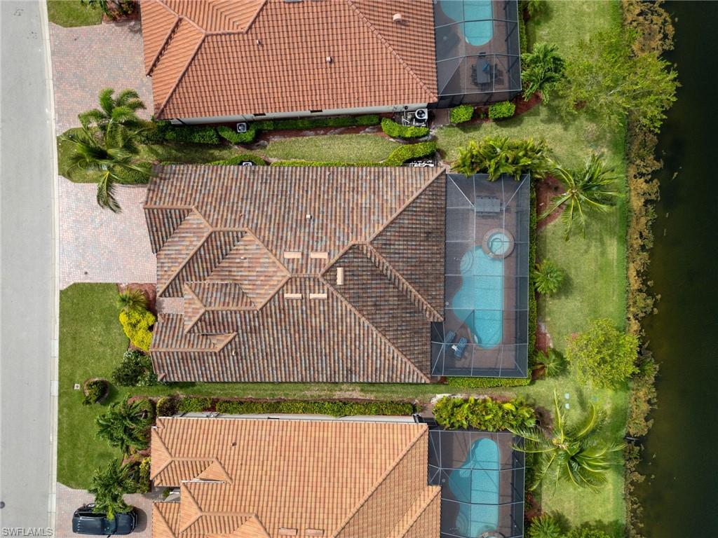 Mediterranean-style tile roof home featuring a screened pool enclosure