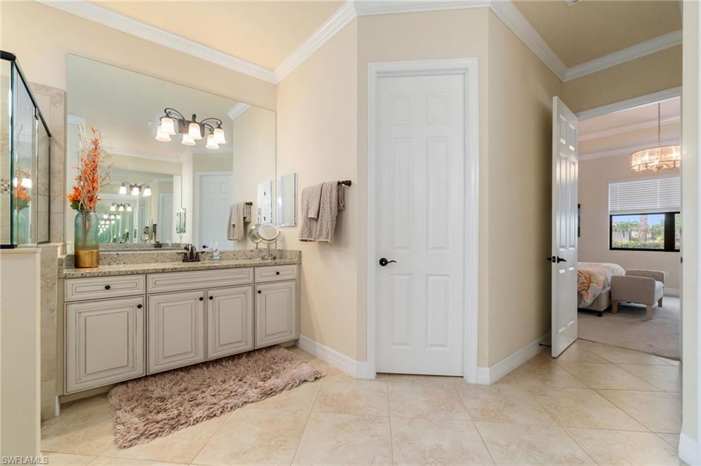 Bathroom vanity featuring light cabinetry, a stone-finish countertop, a large mirror, and a five-light fixture