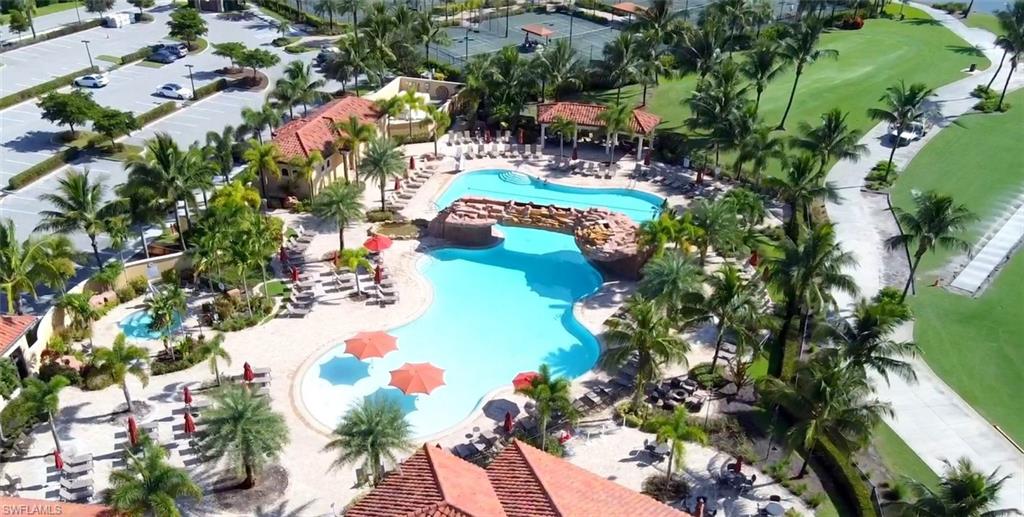 Resort-style aquatic amenity featuring a large freeform swimming pool with a rock bridge and a separate shallow pool