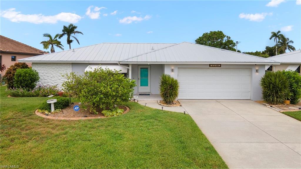 Single story home featuring a garage and a front yard