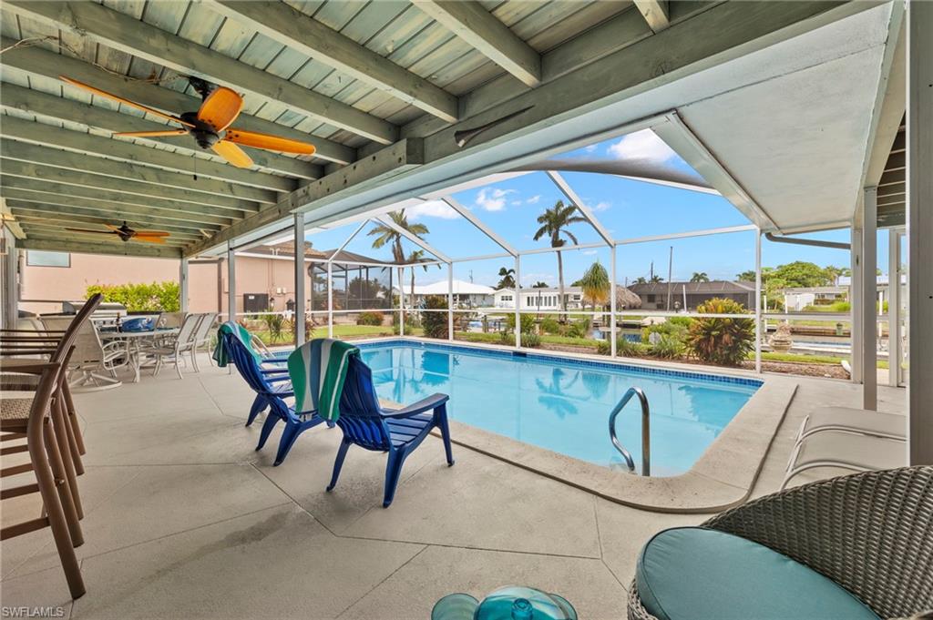 View of swimming pool enclosure, a patio, and ceiling fan