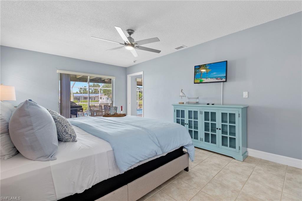 Bedroom featuring ceiling fan, a textured ceiling, and light tile patterned floors