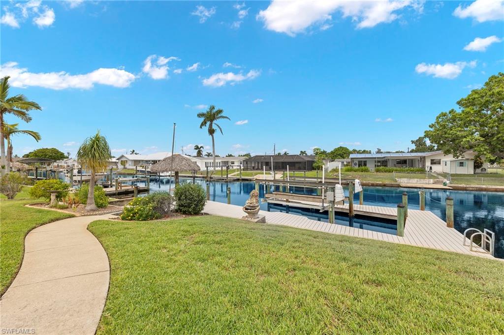 View of dock with a yard and a water view