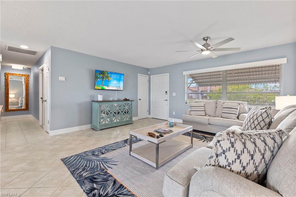 Living room with ceiling fan and light tile patterned floors