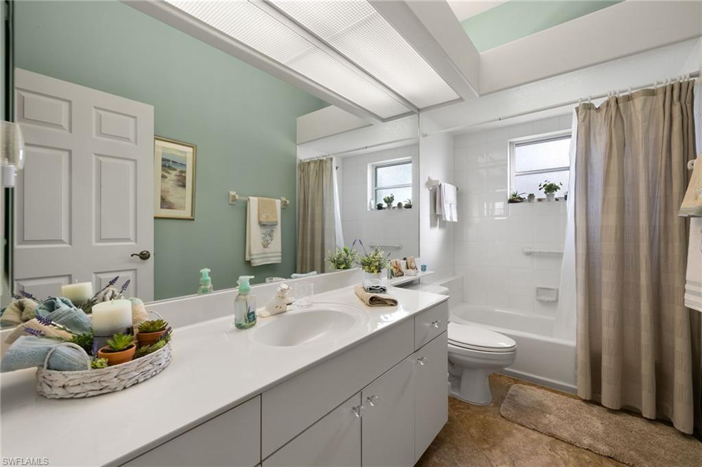 Full bathroom with shower / tub combo with curtain, vanity, and toilet