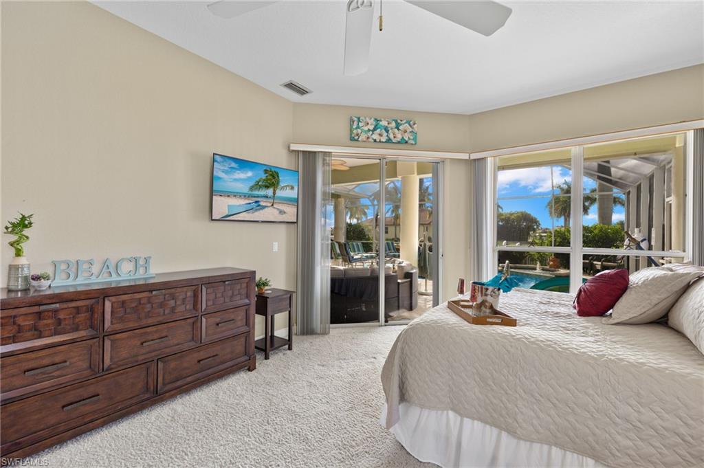 Carpeted bedroom featuring access to outside and ceiling fan