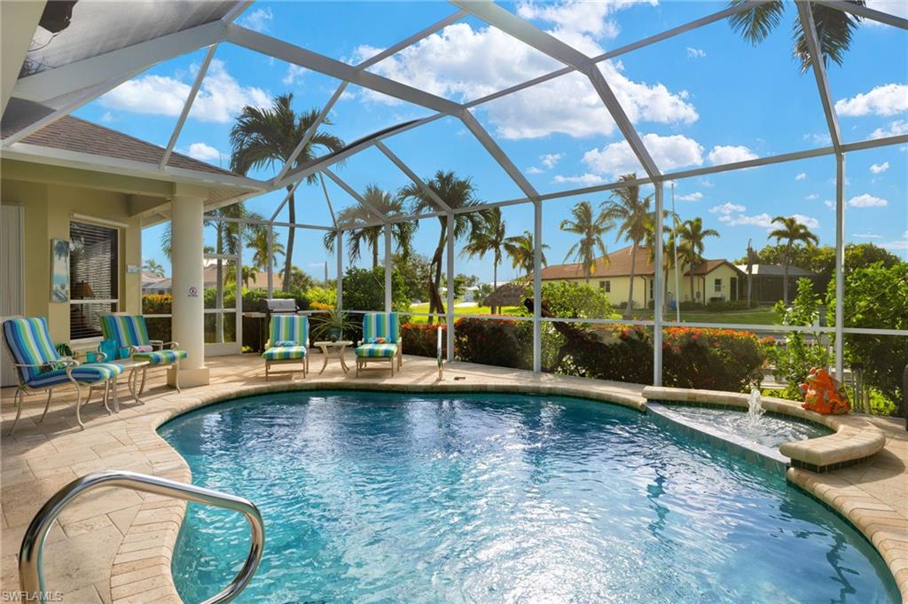 View of pool featuring a patio, pool water feature, and glass enclosure