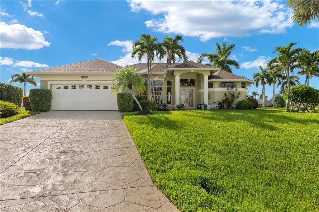 View of front of house featuring a garage and a front lawn