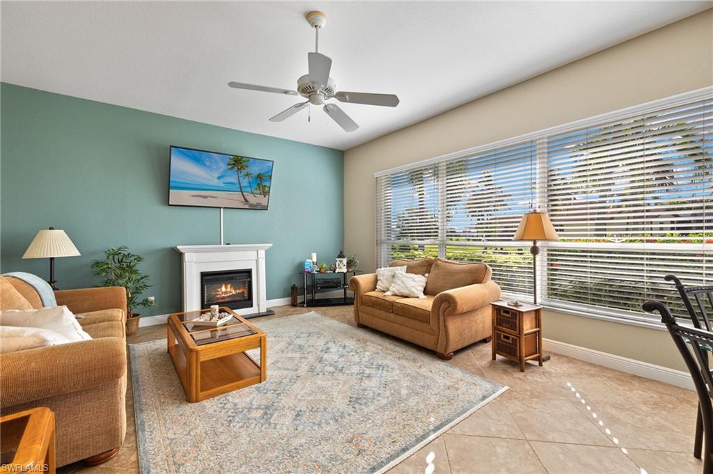Living room with light tile patterned floors and ceiling fan