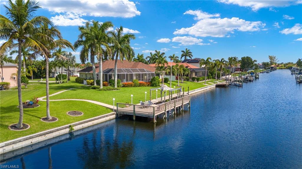 View of dock with a water view, and a lawn
