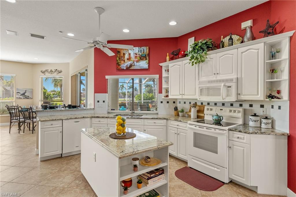 Kitchen featuring cabinetry, ceiling fan, and island