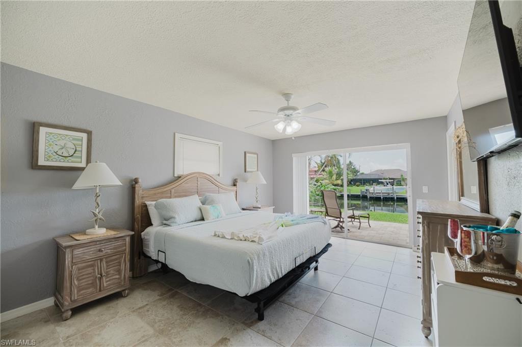 Primary Bedroom with King size bed, view of canal & pool with patio slider.