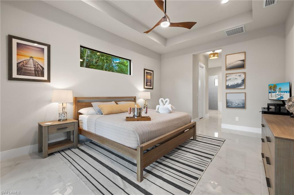 Bedroom featuring a tray ceiling and ceiling fan