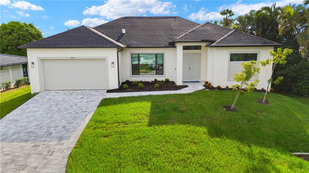 View of front of home with a garage and a front yard