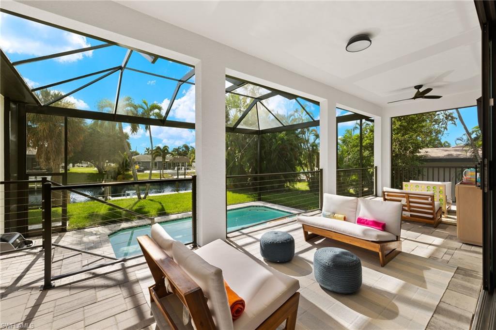 Sunroom / solarium with ceiling fan and a water view