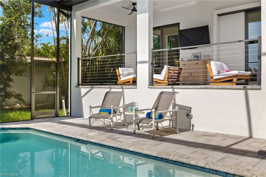 View of pool with a patio and ceiling fan