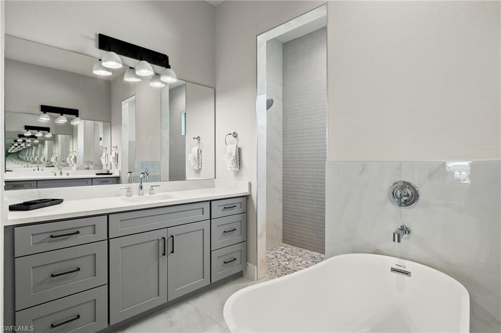 Bathroom with plus walk in shower, tile walls, and vanity