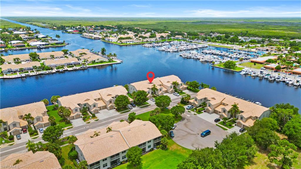 Waterfront community featuring direct canal access, a marina with multiple boat slips, and an adjacent natural landscape