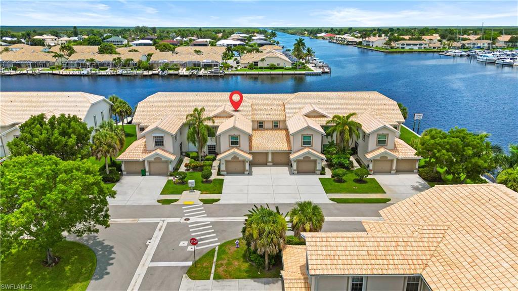 Waterfront townhome-style residences with barrel tile roofs and private garages